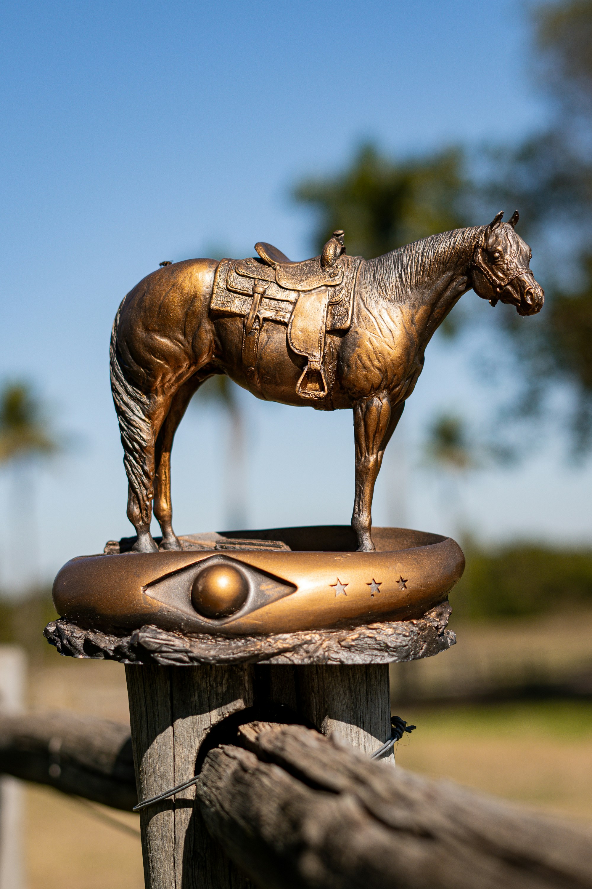a statue of a horse on top of a wooden post