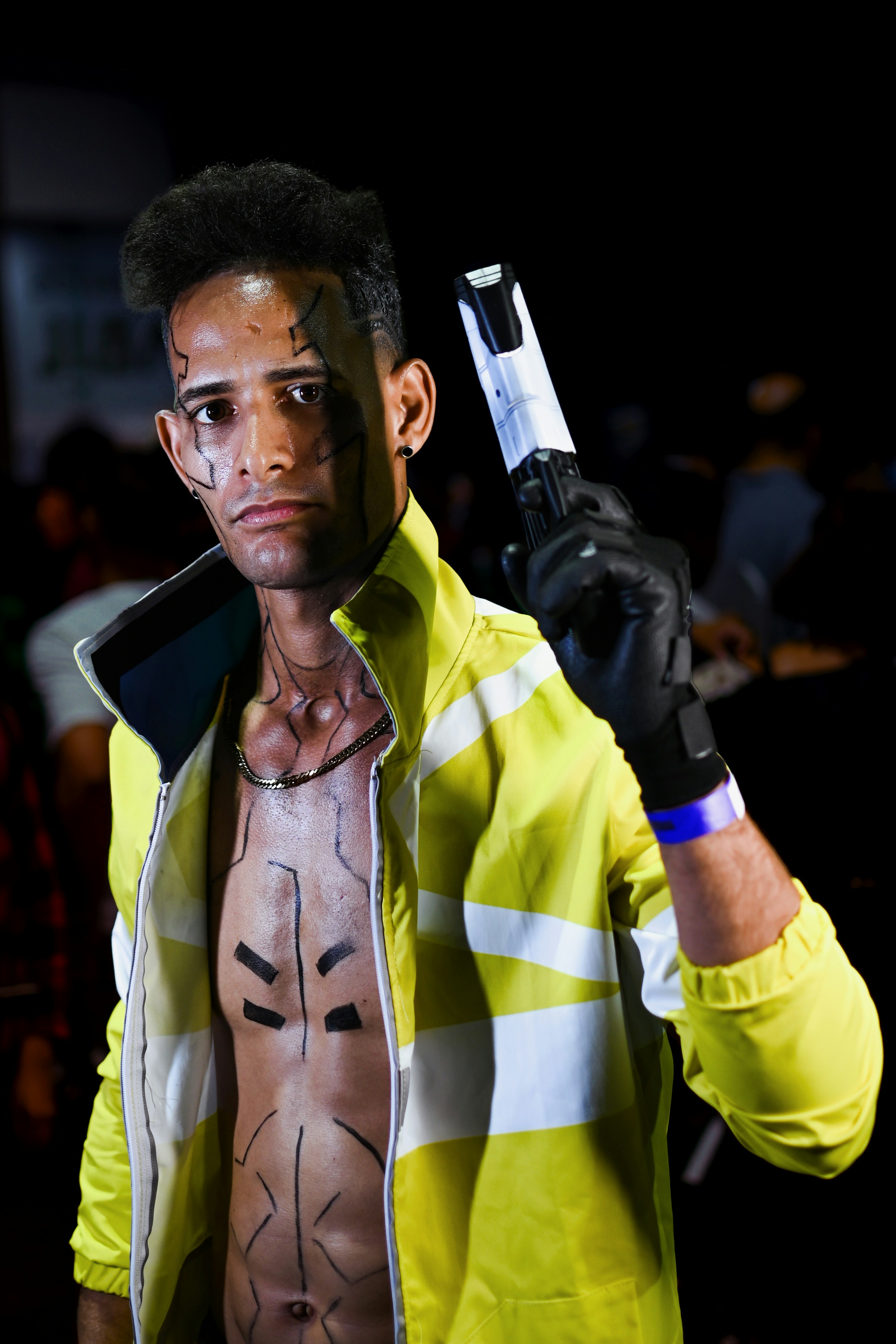 Seorang pria berjaket kuning memegang kamera