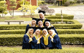 a group of women in graduation gowns posing for a picture