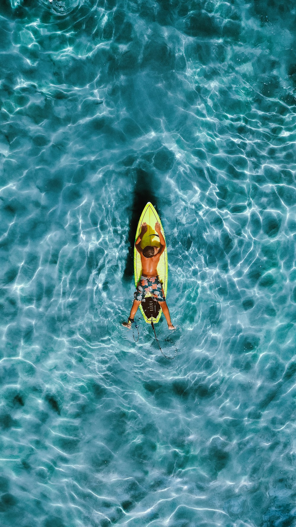 a man riding on top of a yellow kayak in the ocean
