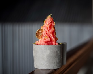 Vibrant mixed berry sorbet served in a clear glass cup with fresh berries on top.