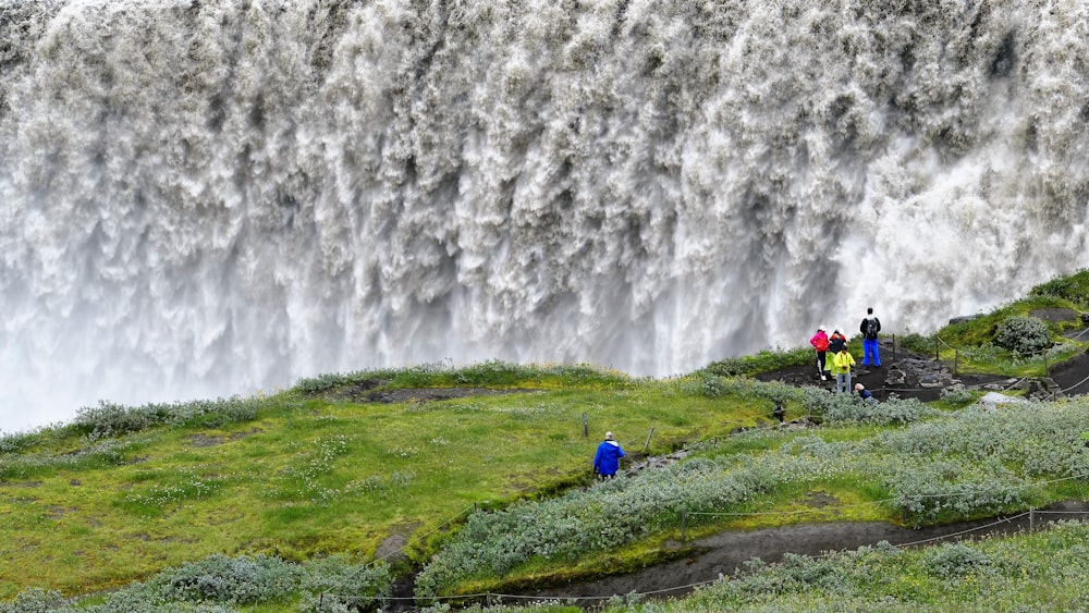 a group of people standing in front of a waterfall