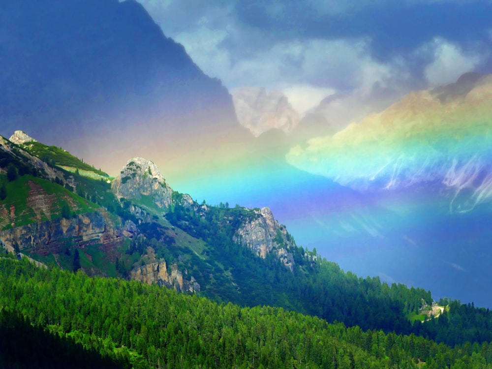 a rainbow in the sky over a mountain range