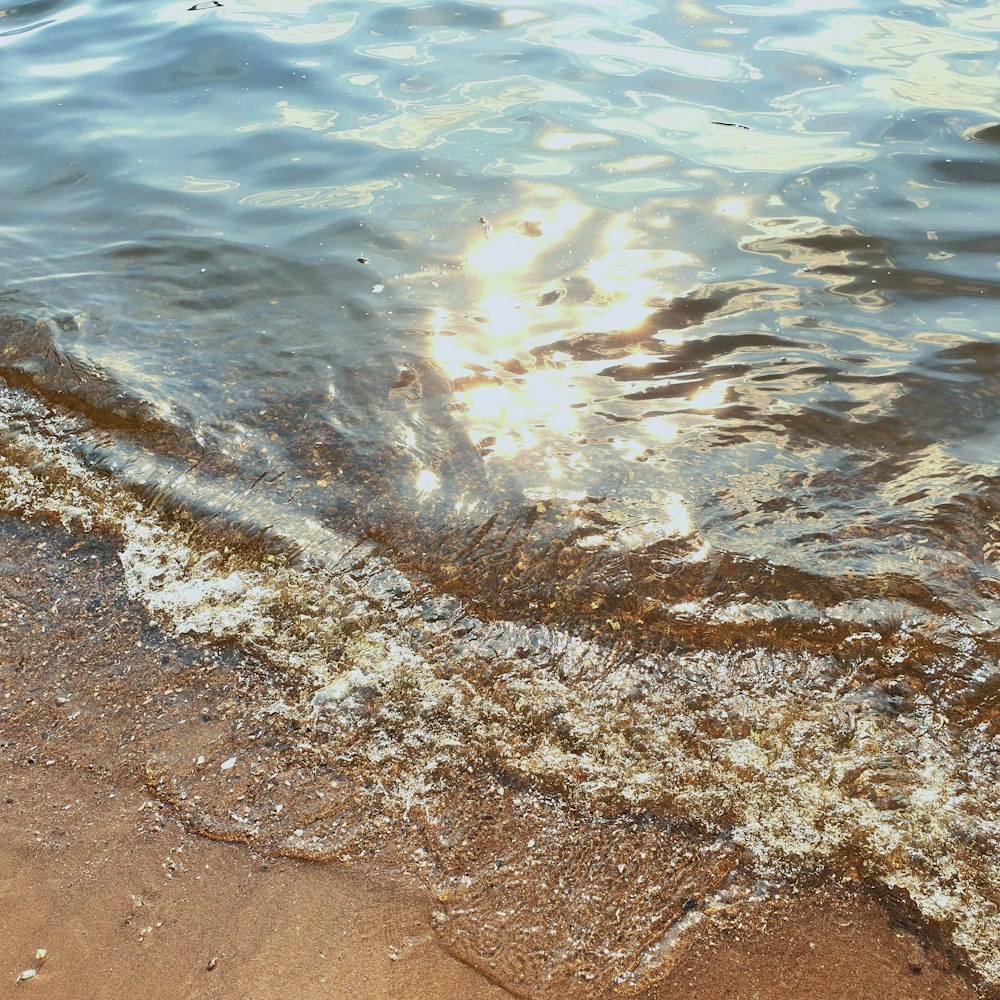 the sun shines through the water on the beach