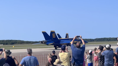 A group of planespotters with cameras and binoculars capturing aircraft near Munich Airport.