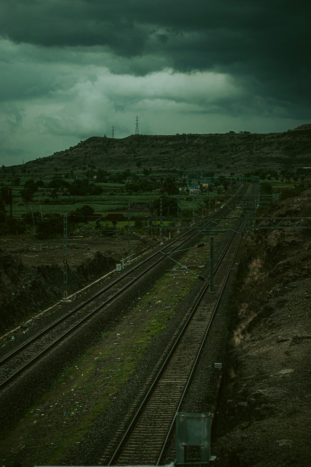a train traveling down tracks under a cloudy sky