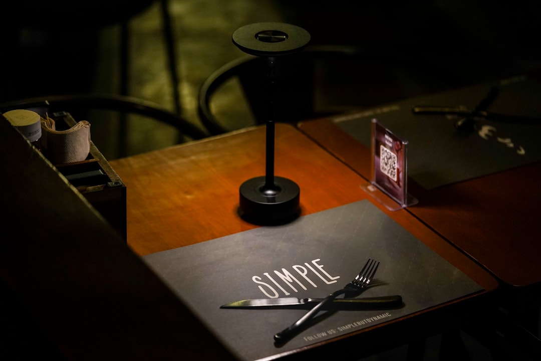 a wooden table topped with a knife and fork,