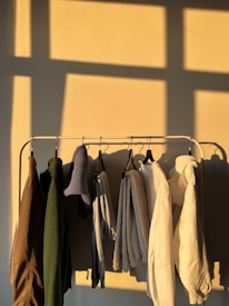 Rows of colorful clothing hanging on racks in a bright studio.