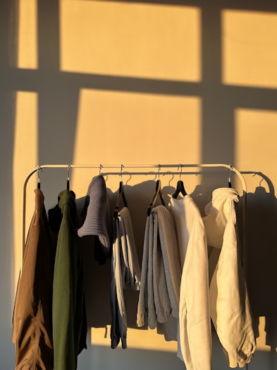 Variety of men's sweaters and hoodies hanging on a rack.