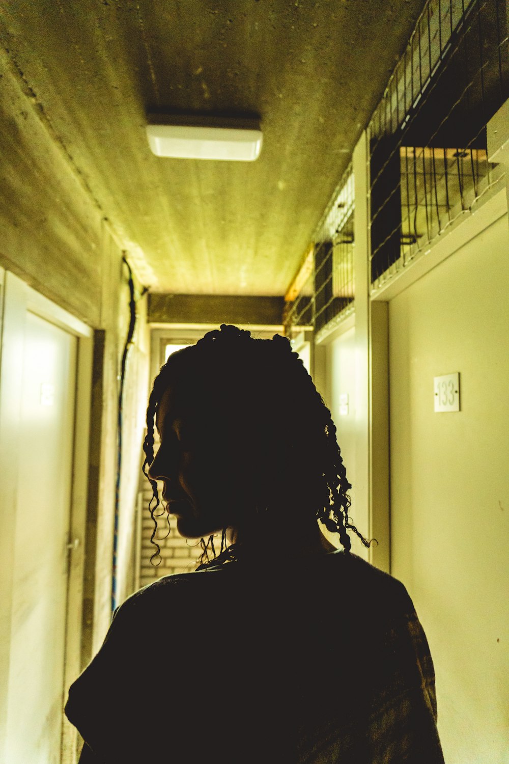 a person standing in a hallway with a light on