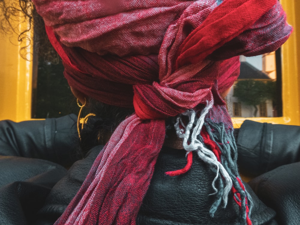 a close up of a person wearing a red scarf
