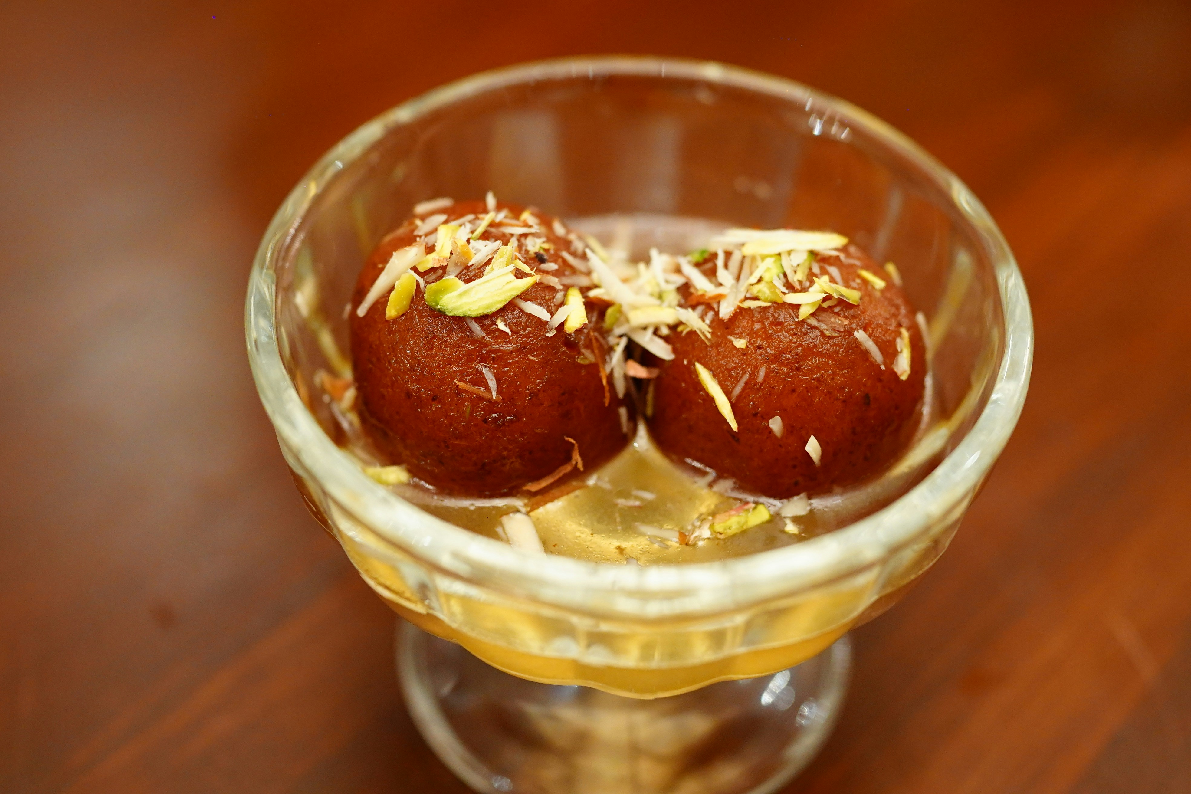Traditional Pakistani dessert platter with gulab jamun, jalebi, and kheer garnished with nuts