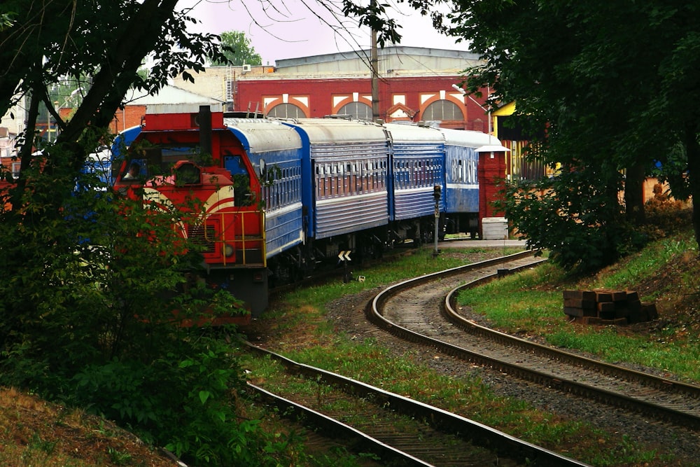 a blue and red train traveling down train tracks