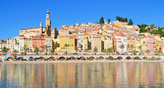 A lively Mediterranean port town bustling with colorful buildings and docked cruise liners.