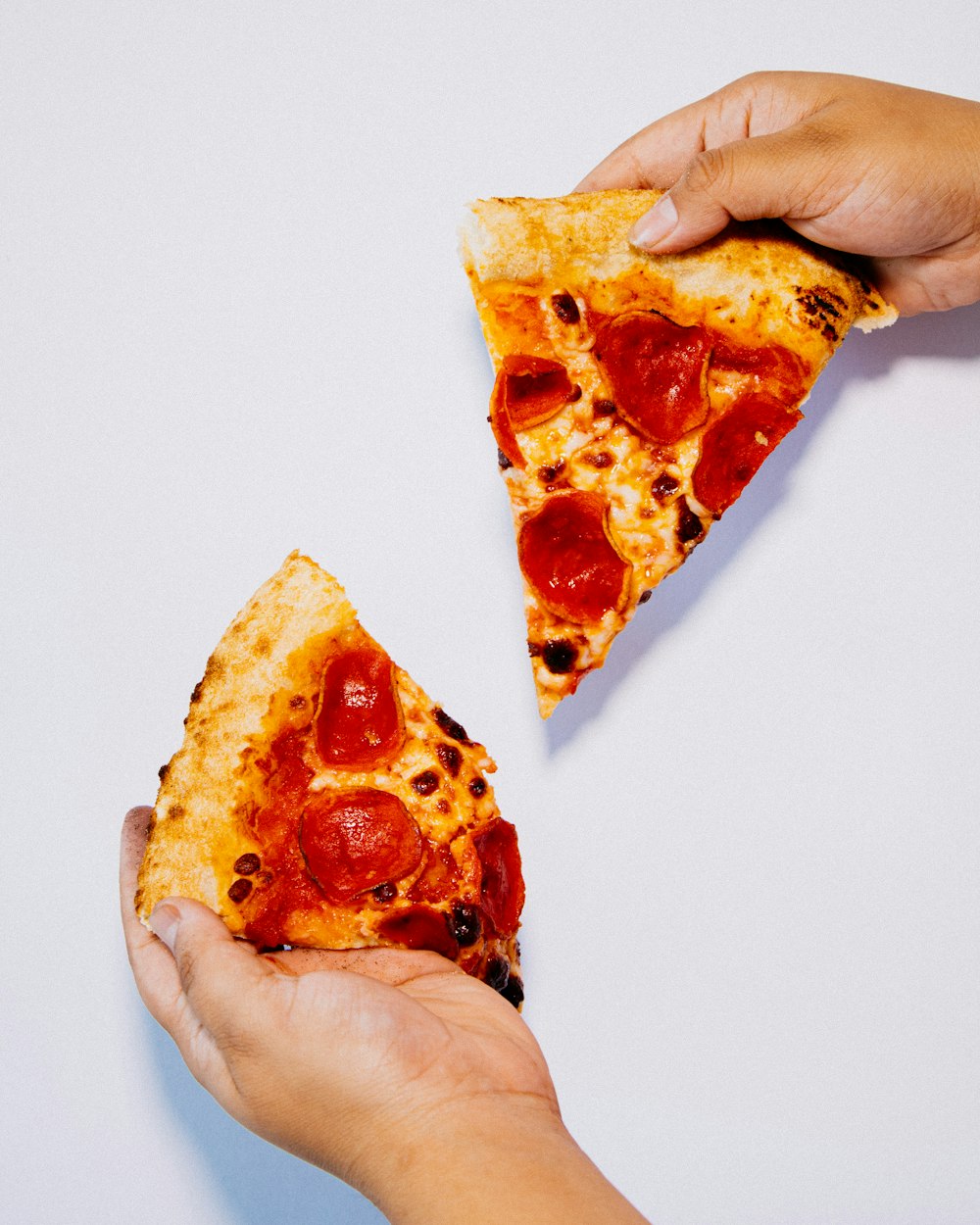 a person holding a slice of pizza in their hands