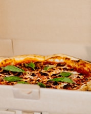 Freshly baked Jesas Pizza being boxed for takeout.