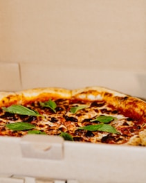 A hot, golden 10-inch cheese pizza fresh out of the oven, ready for delivery in a simple branded box.