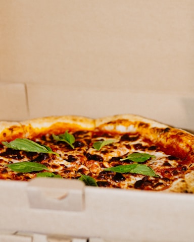 A hot, golden 10-inch cheese pizza fresh out of the oven, ready for delivery in a simple branded box.