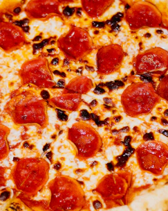 Golden, crispy American-style pizza topped with melted cheese and pepperoni.