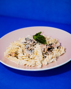 A vibrant plate of cheesy fusion pasta with colorful veggies.