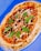 A freshly baked pizza topped with vibrant ingredients on a wooden table.
