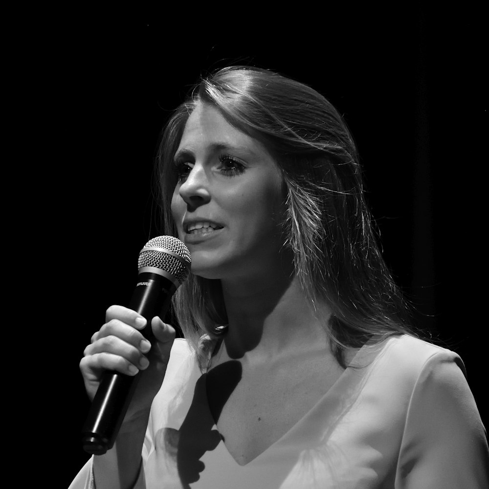 a black and white photo of a woman holding a microphone