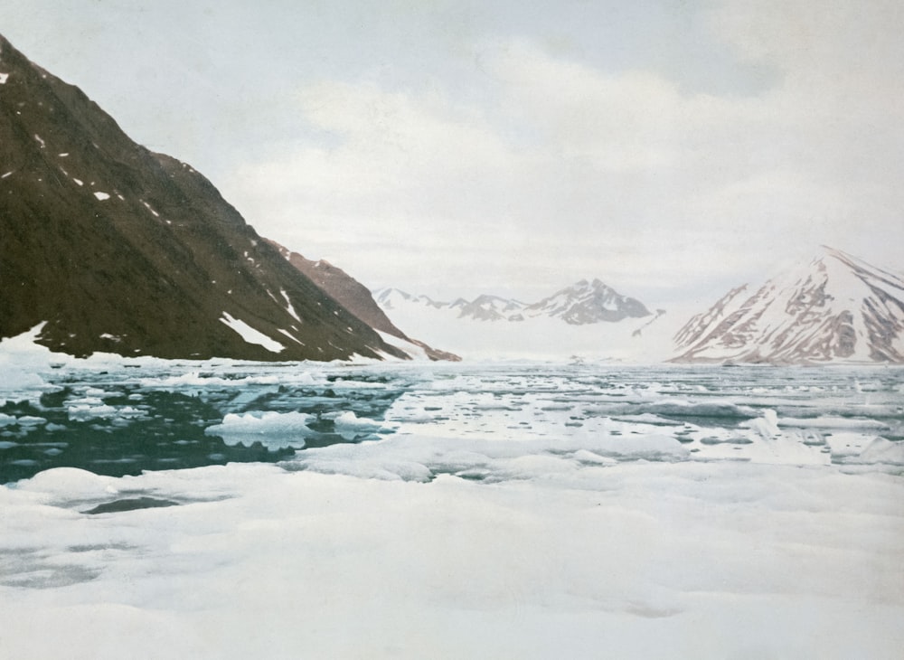 a picture of some mountains and ice in the water