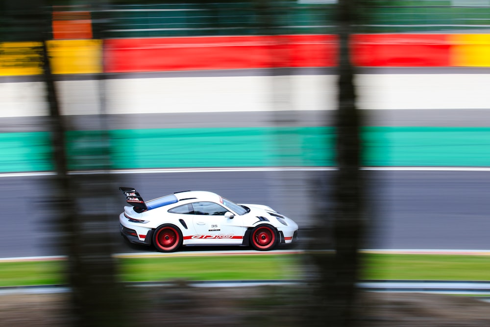 a white sports car driving down a race track