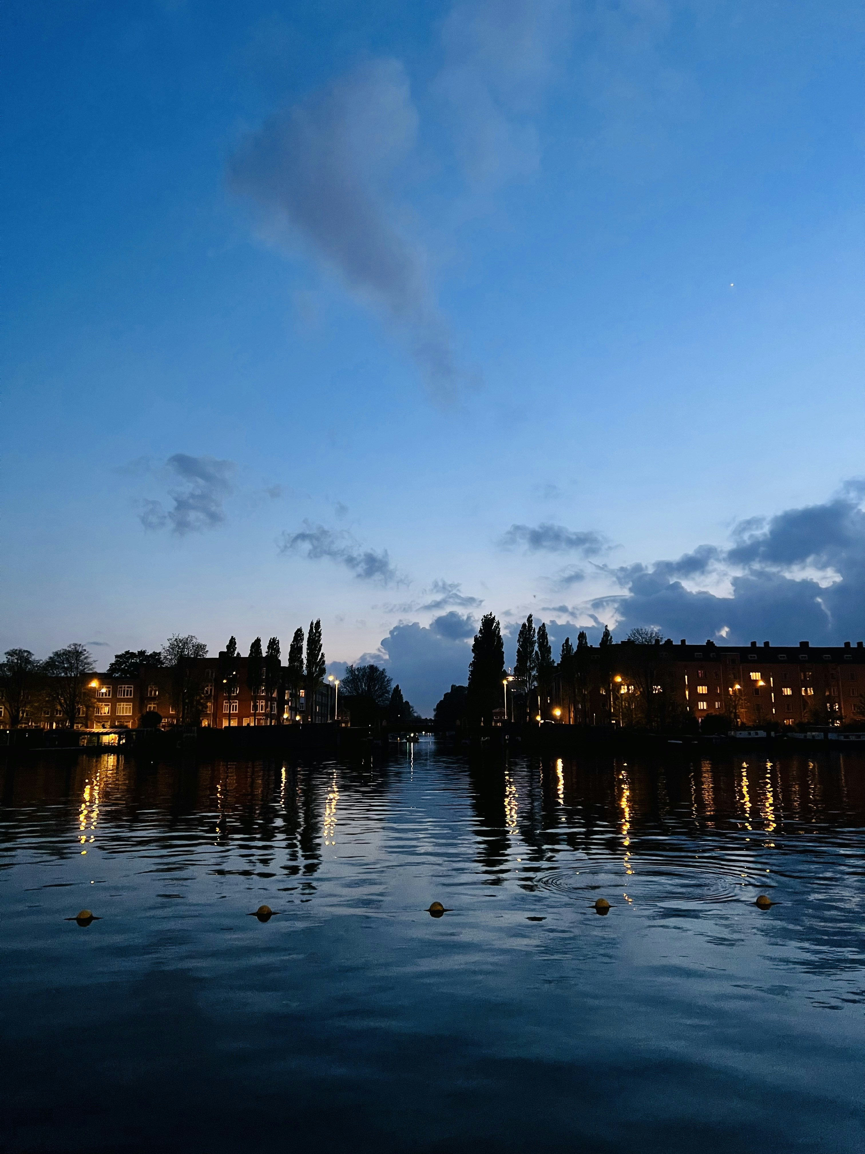 a body of water at night with buildings in the background