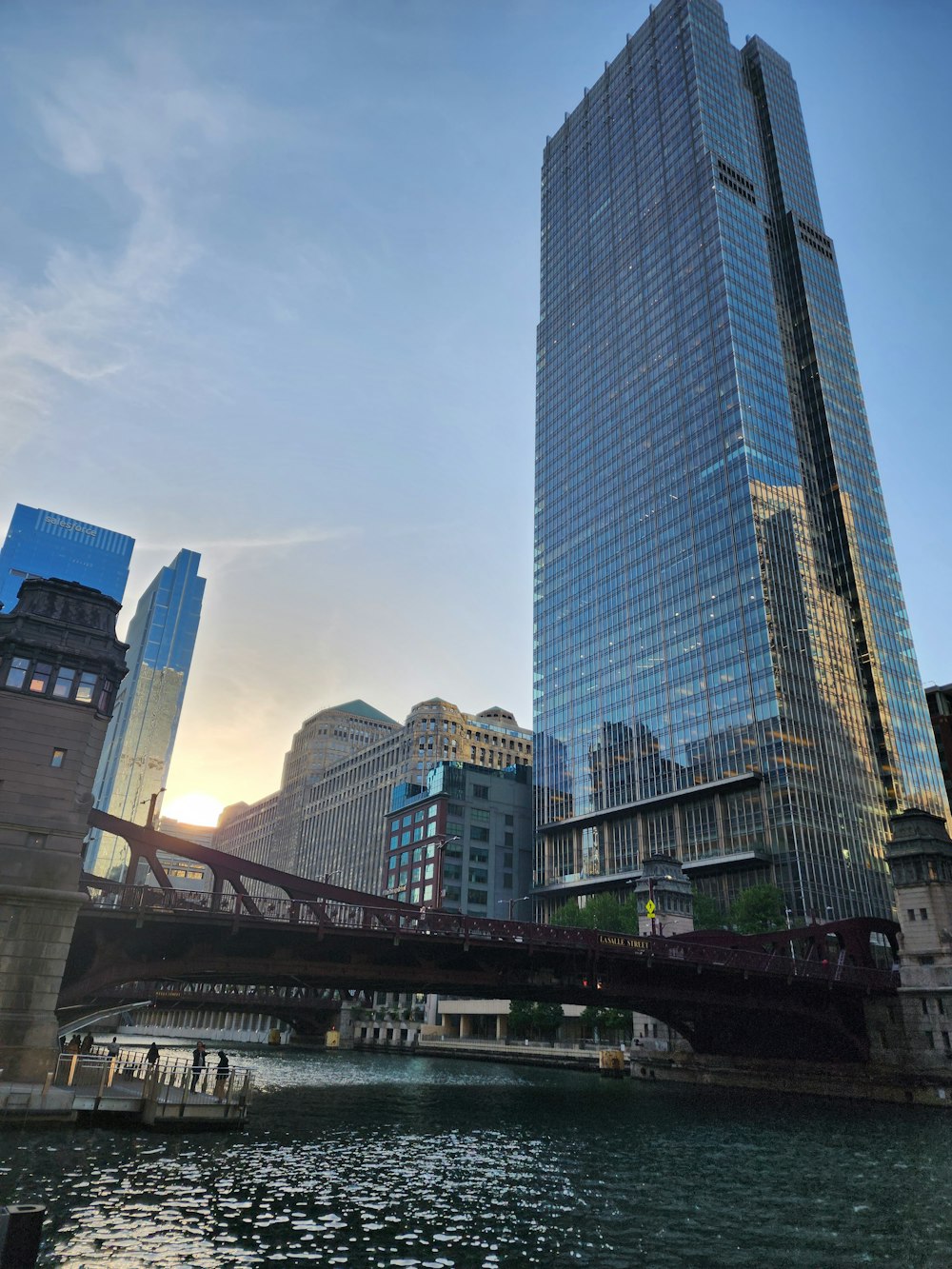 a bridge over a body of water in front of tall buildings