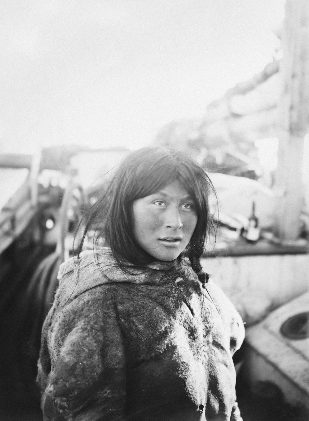 a black and white photo of a woman in a fur coat