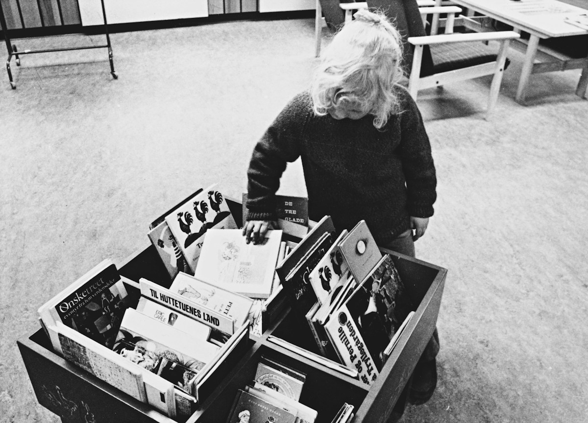 A young girl stands inside an open suitcase, symbolizing back-to-school event planning and PTA sign-up activities.