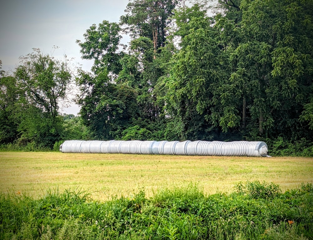 a large roll of hay sitting on top of a lush green field