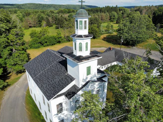 an aerial view of a church in the woods