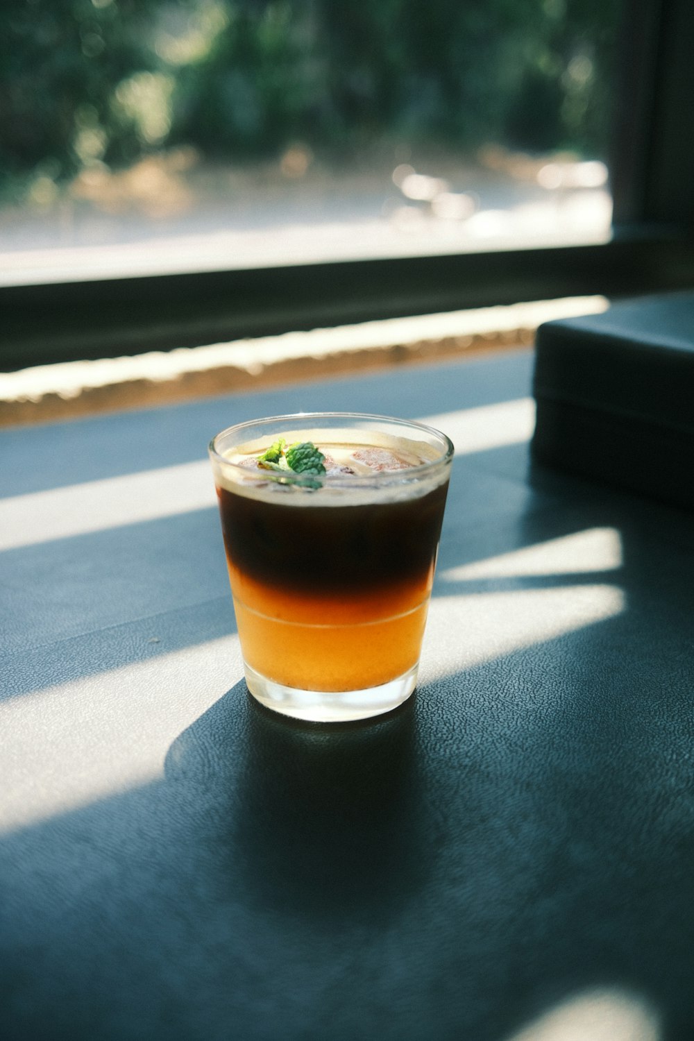 a drink sitting on top of a table next to a window