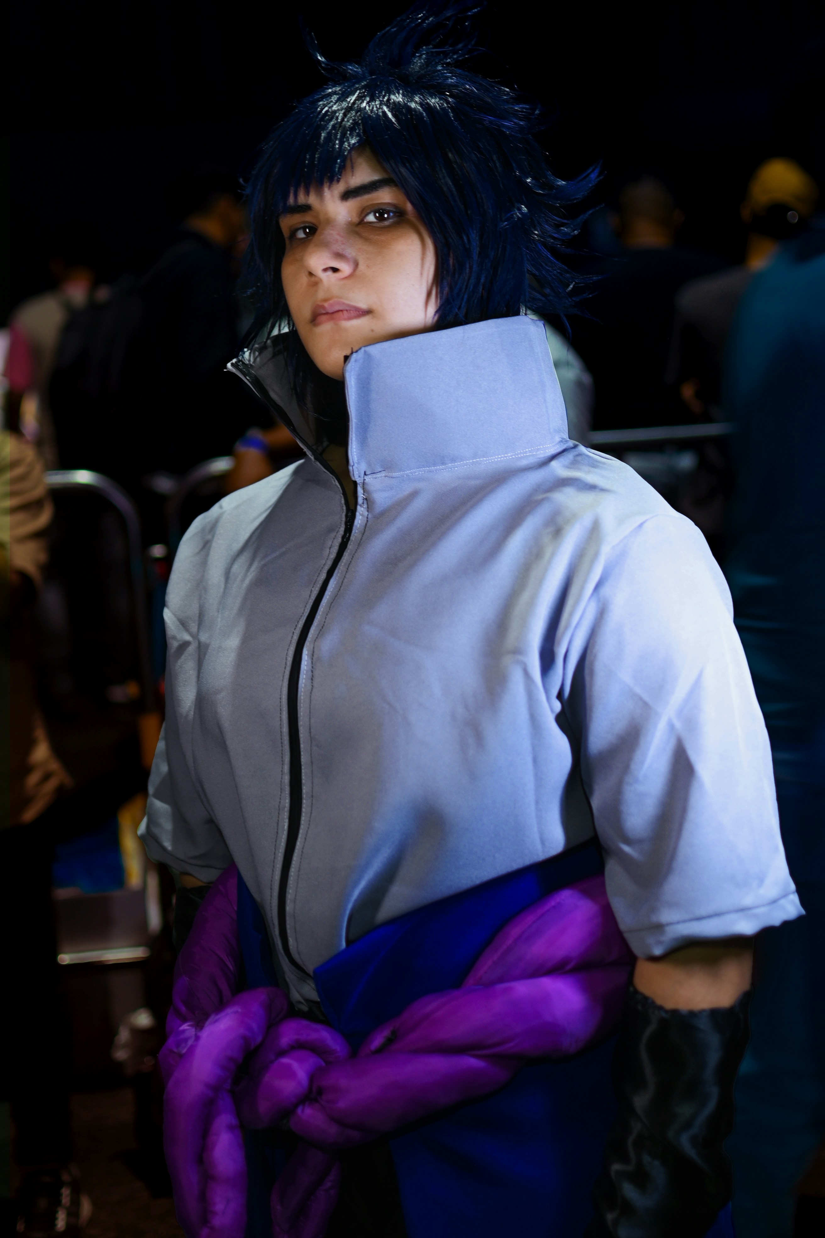 Seorang wanita dengan pakaian cosplay dengan sarung tangan ungu