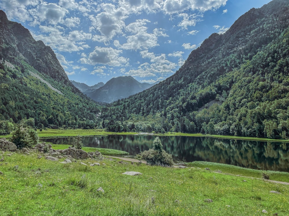 a scenic view of a mountain valley with a lake in the foreground