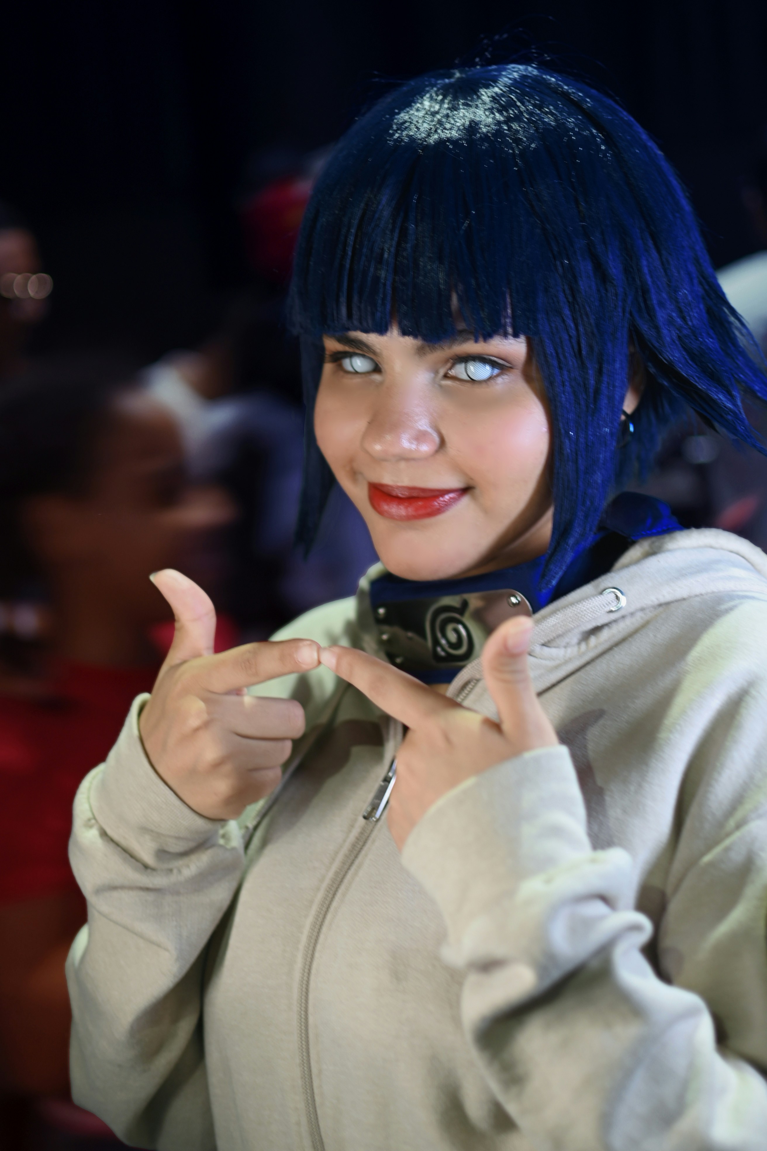 Seorang wanita dengan rambut biru membuat tanda perdamaian