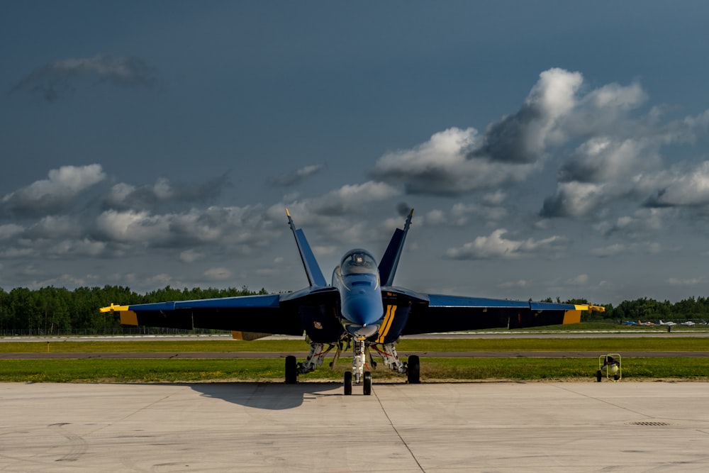 a blue and yellow jet sitting on top of an airport tarmac
