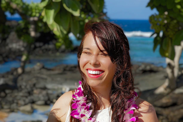 Close-up of a smiling traveler holding a booking confirmation on a tropical island.