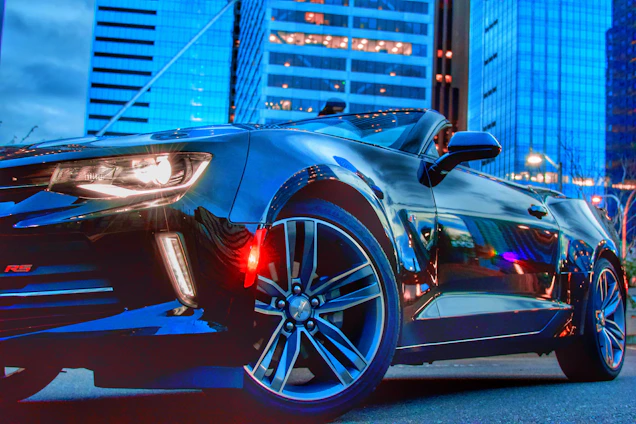 A sleek black sports car illuminated under city lights, reflecting the premium and dynamic spirit of SkylineMiles.