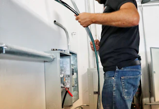 A skilled worker fixing electrical wiring inside a residential home.
