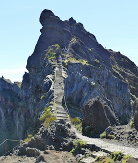 A person climbing a steep mountain path, symbolizing overcoming challenges and achieving success.