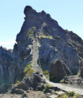 A person climbing a steep mountain path, symbolizing overcoming challenges and achieving success.
