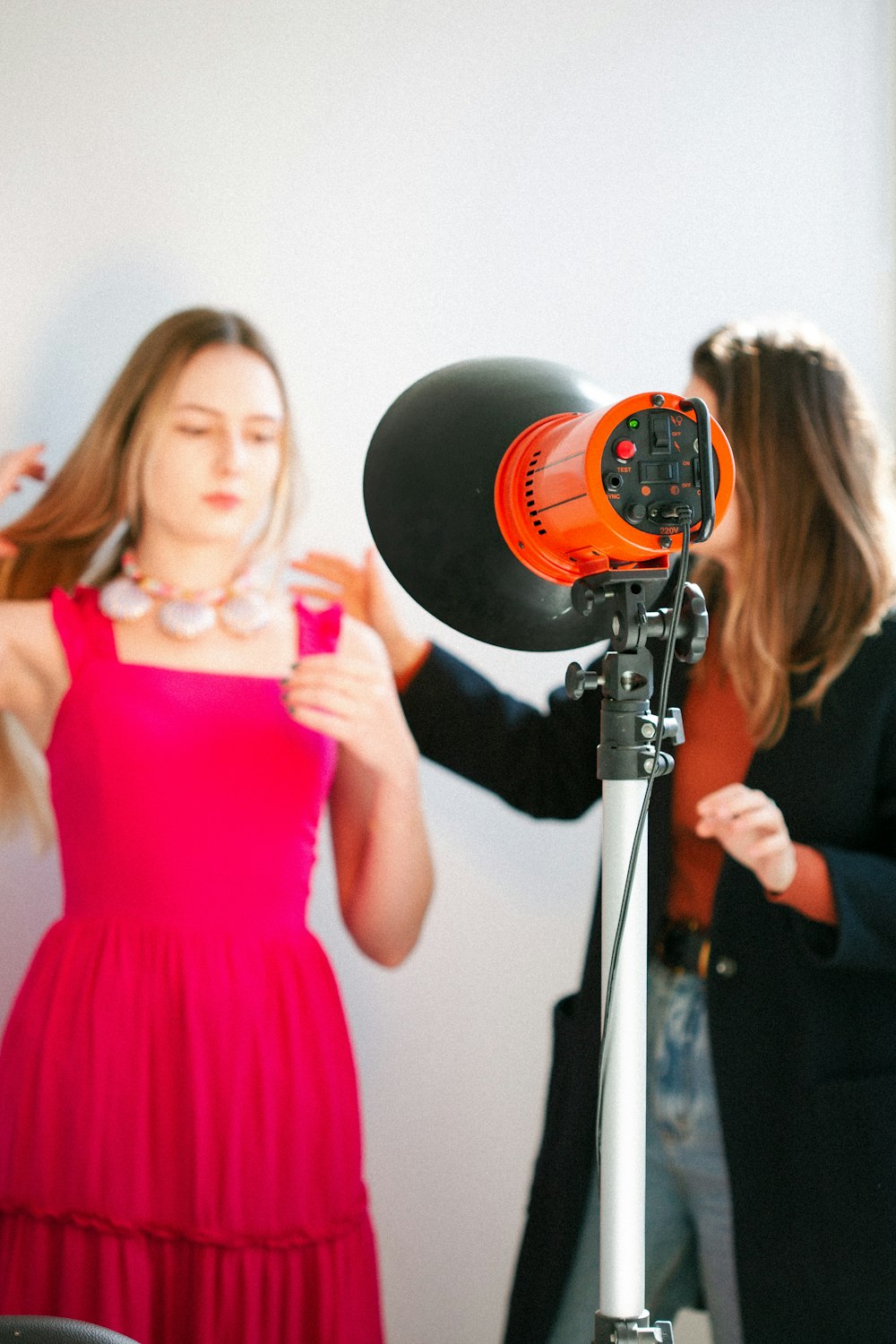 a woman standing next to a camera and another woman