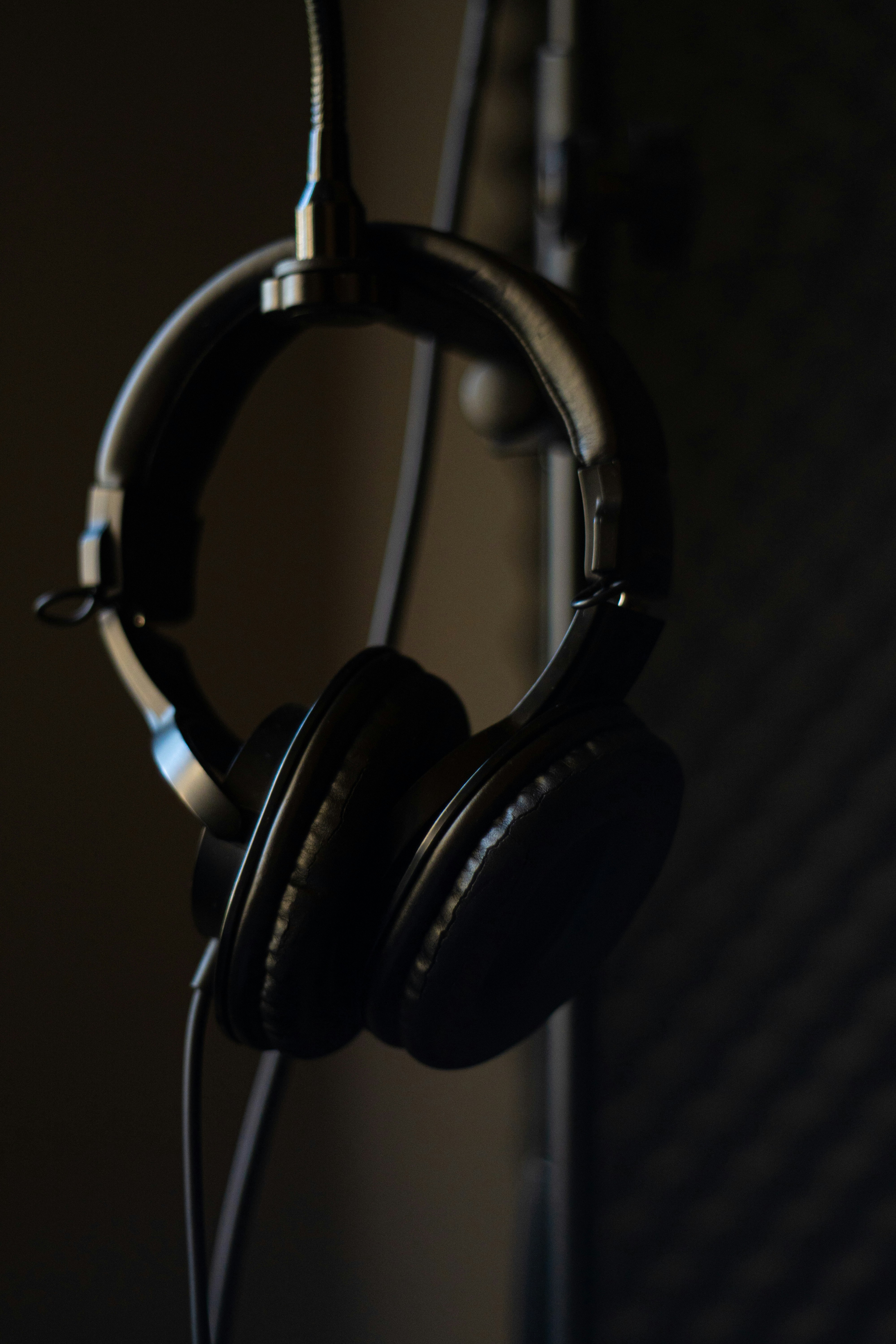 Premium over-ear headphones on dark surface, dramatic studio lighting, luxury tech
