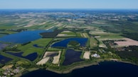 An aerial view of a diverse landscape featuring farms and water bodies.