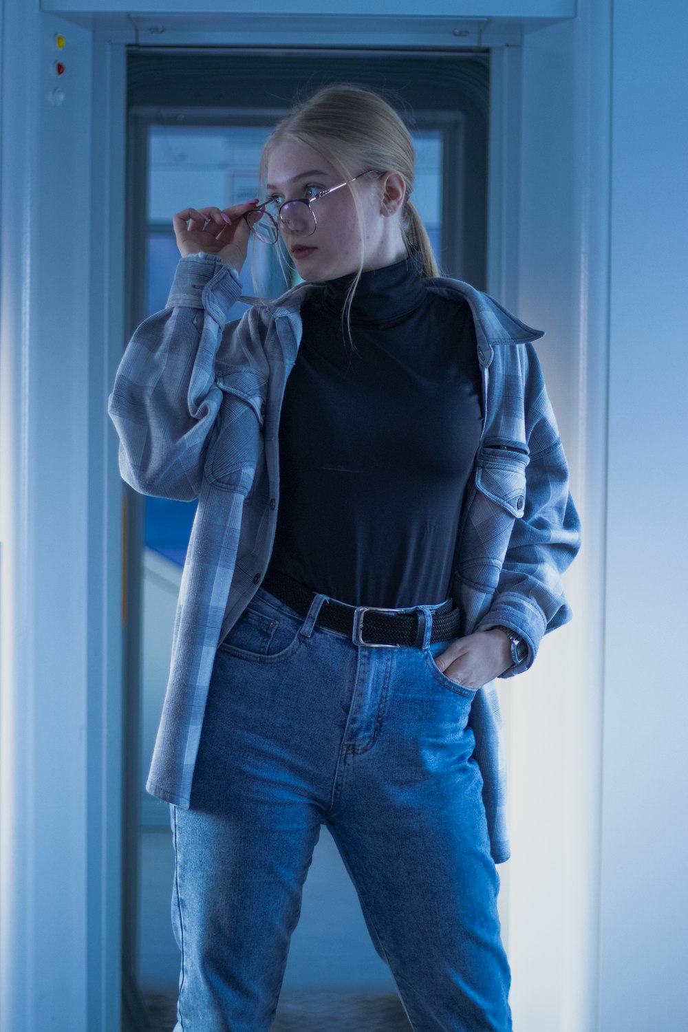 a woman in a black shirt and jeans is talking on a cell phone