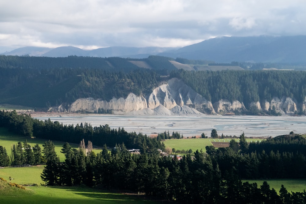 a scenic view of a mountain range with a lake in the foreground