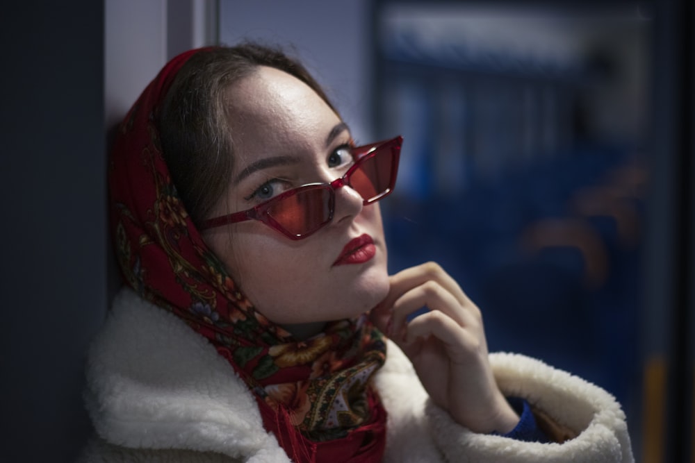 a woman wearing red glasses and a scarf